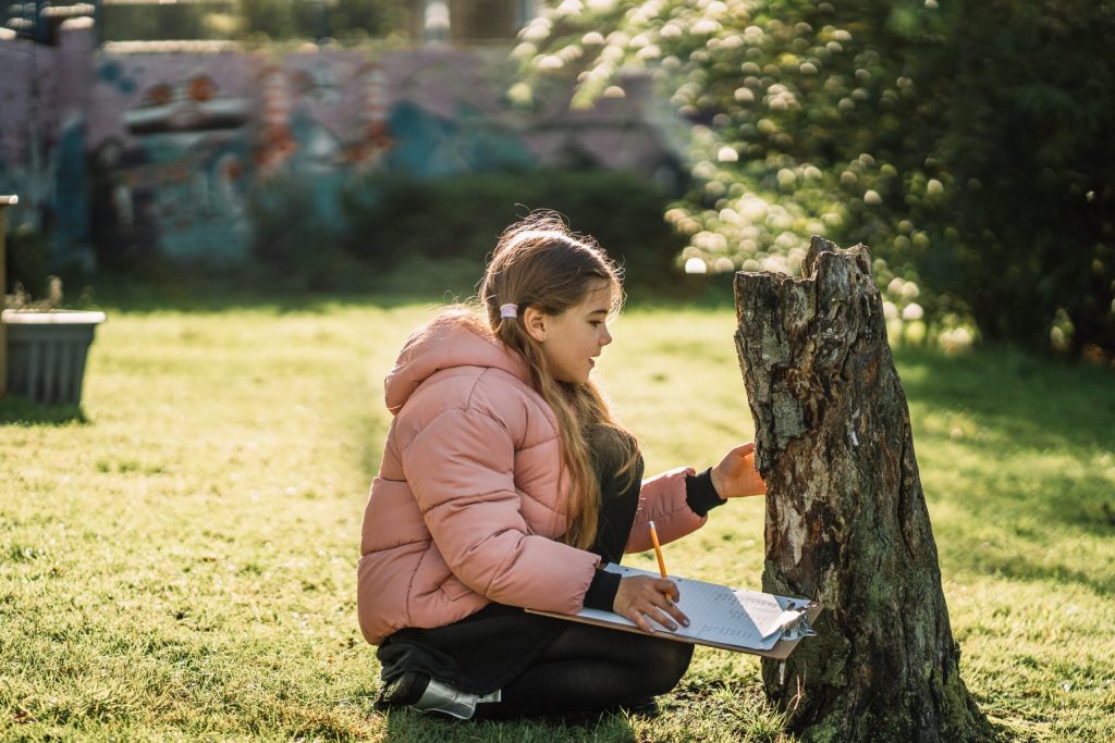 Girl studying tree trunk